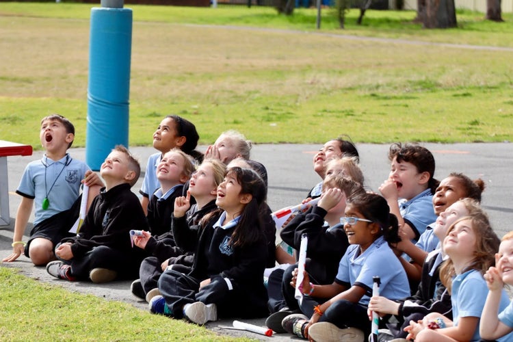 a group of students watching a science show in amazement