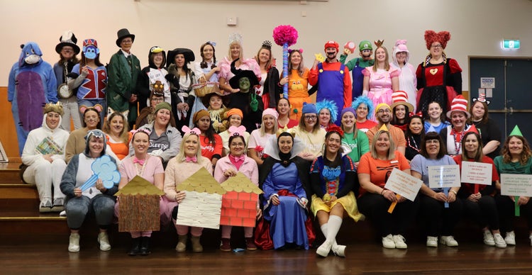 group photo of all staff in dress up clothes from book week