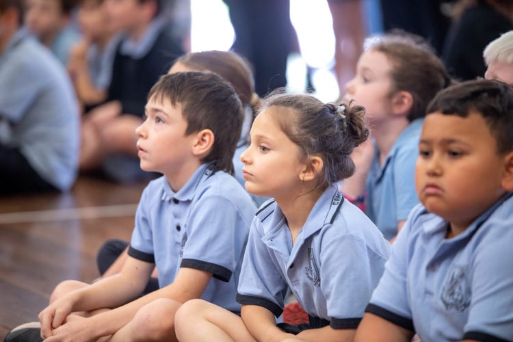 a photo of children sitting on the floor at assembly